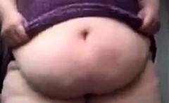 SSBBW in a purple dress plays with her giant belly