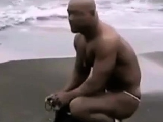 Asian bodybuilder barely covered at the beach